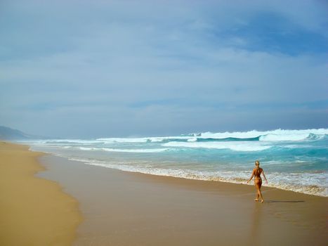 Young lady walking alone along the beach