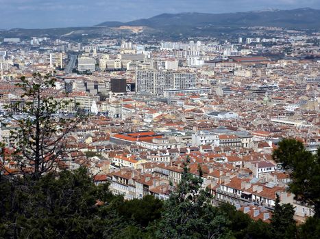 Aerial view of Marseilles city with all the colored roofs of the buildings and the mountain behind, France