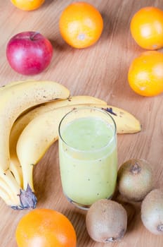 Glass of smoothie with fresh fruits on the table