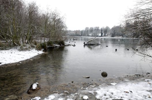 A view of a lake in winter with snow