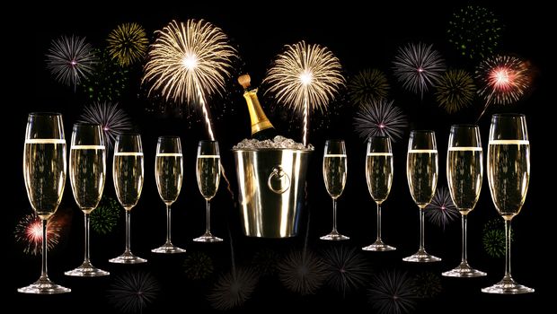 Glasses of champagne with silver ice bucket and fireworks