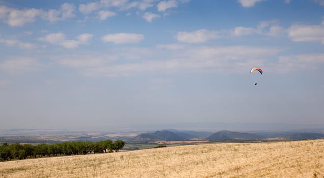 Paraglider flying over the field