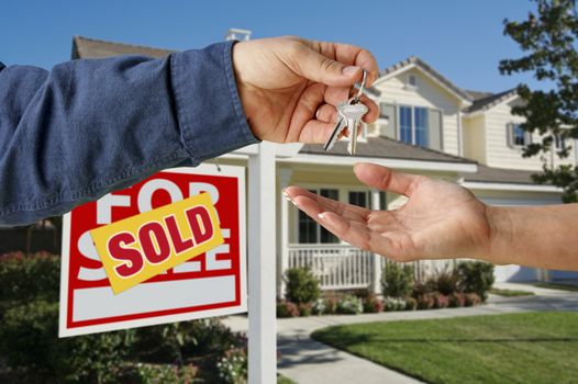Handing Over the Keys to A New Home with Sold Home For Sale Sign.
