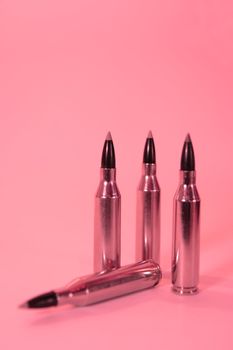 ammunition all in a row on a pink background