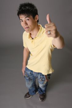 Happy young man of Asian with thumbs up gesture.