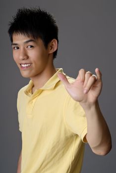 Smiling young man with shaka gesture to greet.