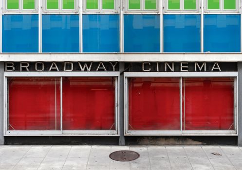 The old facade of an abandoned cinema with neon lights and empty display windows. NOTE: Broadway Cinema is not a business name - this image is comprised of two merged photos.