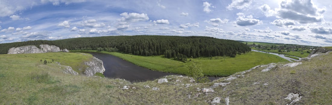 Small river flows between hills. The main object on shot is breakage with fields and wood. On the right side you can see small village. Shot was taken in june at 15:00.