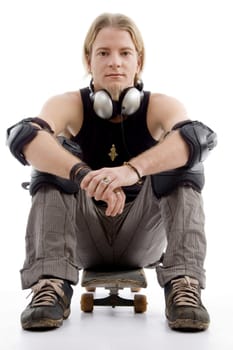 handsome american male sitting on skateboard with white background