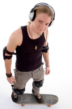 young caucasian guy standing on skateboard and looking at camera on an isolated white background