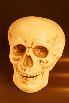 Imitation of a human skull by candlelight on dark background