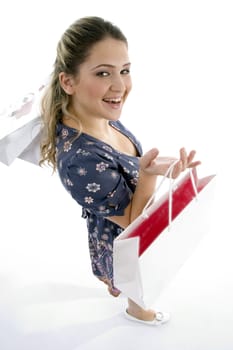 smiling woman holding shopping bags on an isolated white background