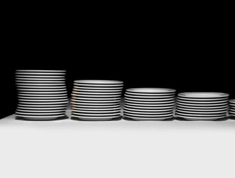 Pile of white plates on a black background
