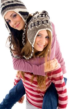 young girl giving piggyback to her friend against white background