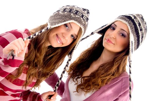 pretty girls wearing cap and looking at camera against white background