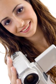 young female holding handy cam and looking at camera on an isolated white background