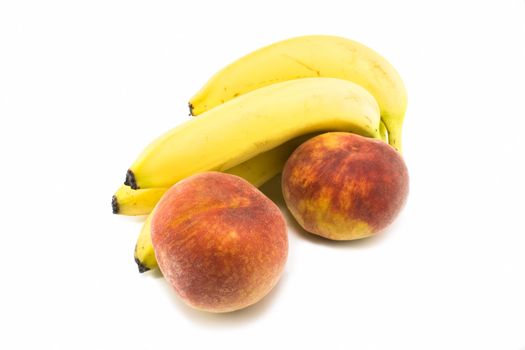 Fresh bananas and peaches on white background