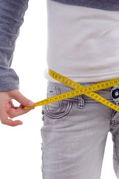 female measuring her waist with tape with white background