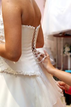 woman puts on beautiful white wedding dress