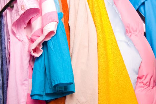 Close up of colorful child clothes in closet
