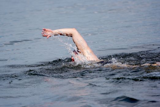 swimming man in action, one hand above water