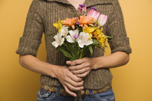Asian woman holding bouquet of flowers.