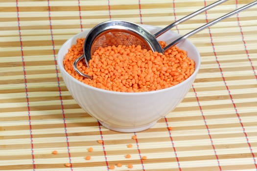 Orange Lentils in a bowl and a metal colander