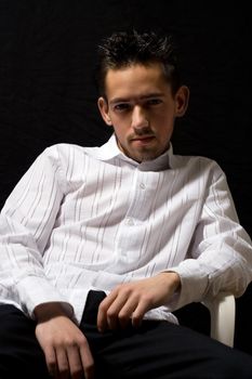 man in white shirt sitting in a chair