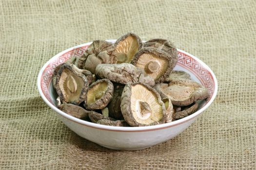 Shiitake Mushrooms in a bowl on brown background