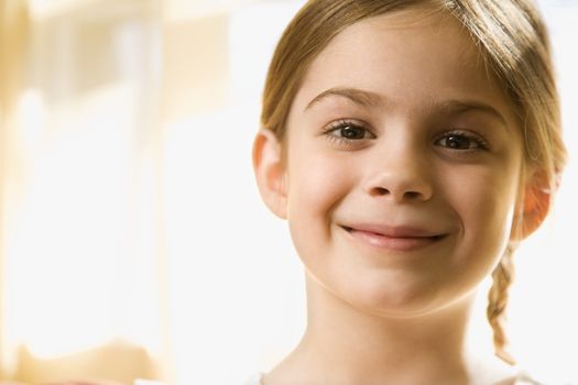 Caucasian girl smiling at viewer.