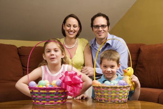 Caucasian family with Easter baskets looking at viewer.