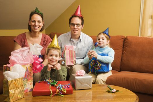 Caucasian family celebrating a birthday party and looking at viewer.