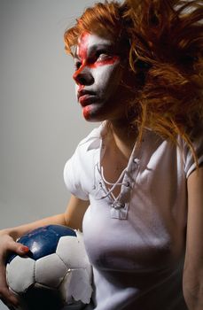 english football makeup girl holding worn soccer ball, looking forward