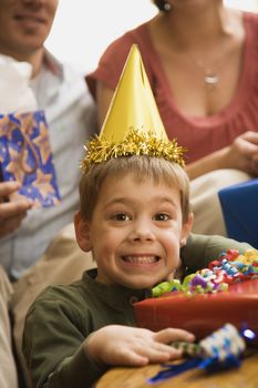 Caucasian boy at birthday party looking at viewer making facial expression.