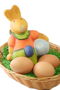 Basket with eggs and bunny on bright background
