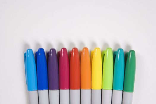 Group of colorful markers lined up in a row.