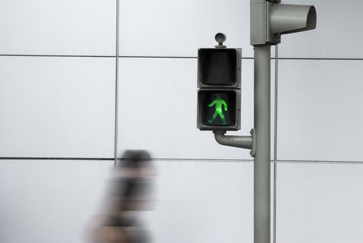 People crossing the road in motion efect with the green safe signal.