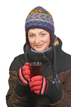 Young woman in winter dress holding a glass of tea