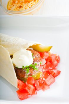 fresh traditional falafel wrap on pita bread with fresh chopped tomatoes