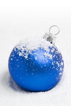 Blue christmas ball lying on the snow. aRGB.