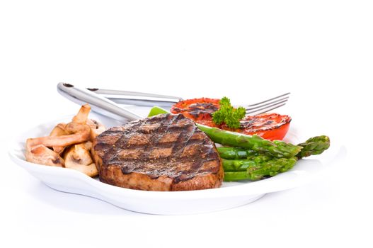 Grilled eye of round steak served with vegetables.