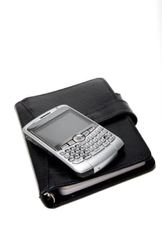 Closed Black Planner, with a silver PDA on top. On white.