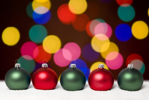 Christmas balls lying on the snow. Background - colorful christams lights. aRGB.