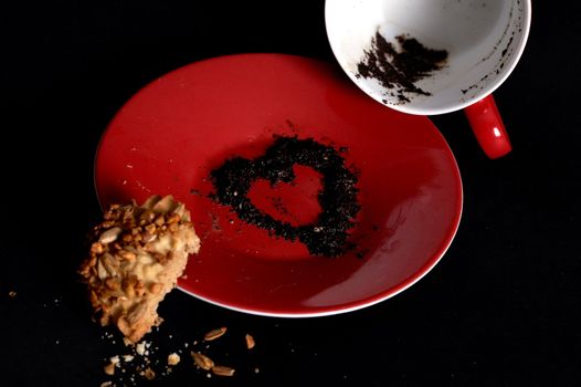 Heart of sediment on the plate. Black background