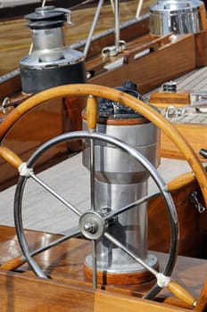 Detail of an old-fashioned boat deck with rudder, compass and other navigation tools