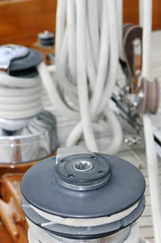 Detail of a winch with other equimpment of a sailboat in background