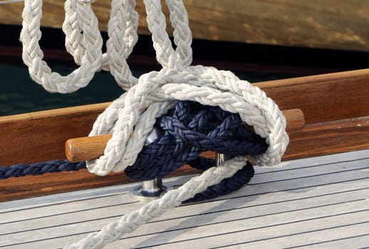 Close-up of a bitt with ropes on a wooden boat