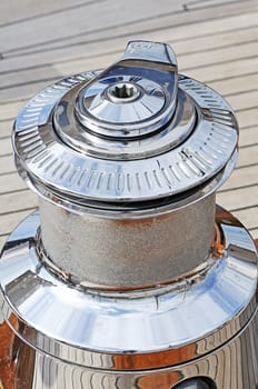 Close-up of a chromium plated winch on a wooden sailboat