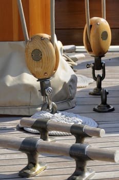 Detail of a deck on a wooden sailboat with bitts and blocks