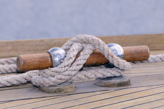 Close-up of a rope tied-up on a bitt fasten a wooden boat to dock